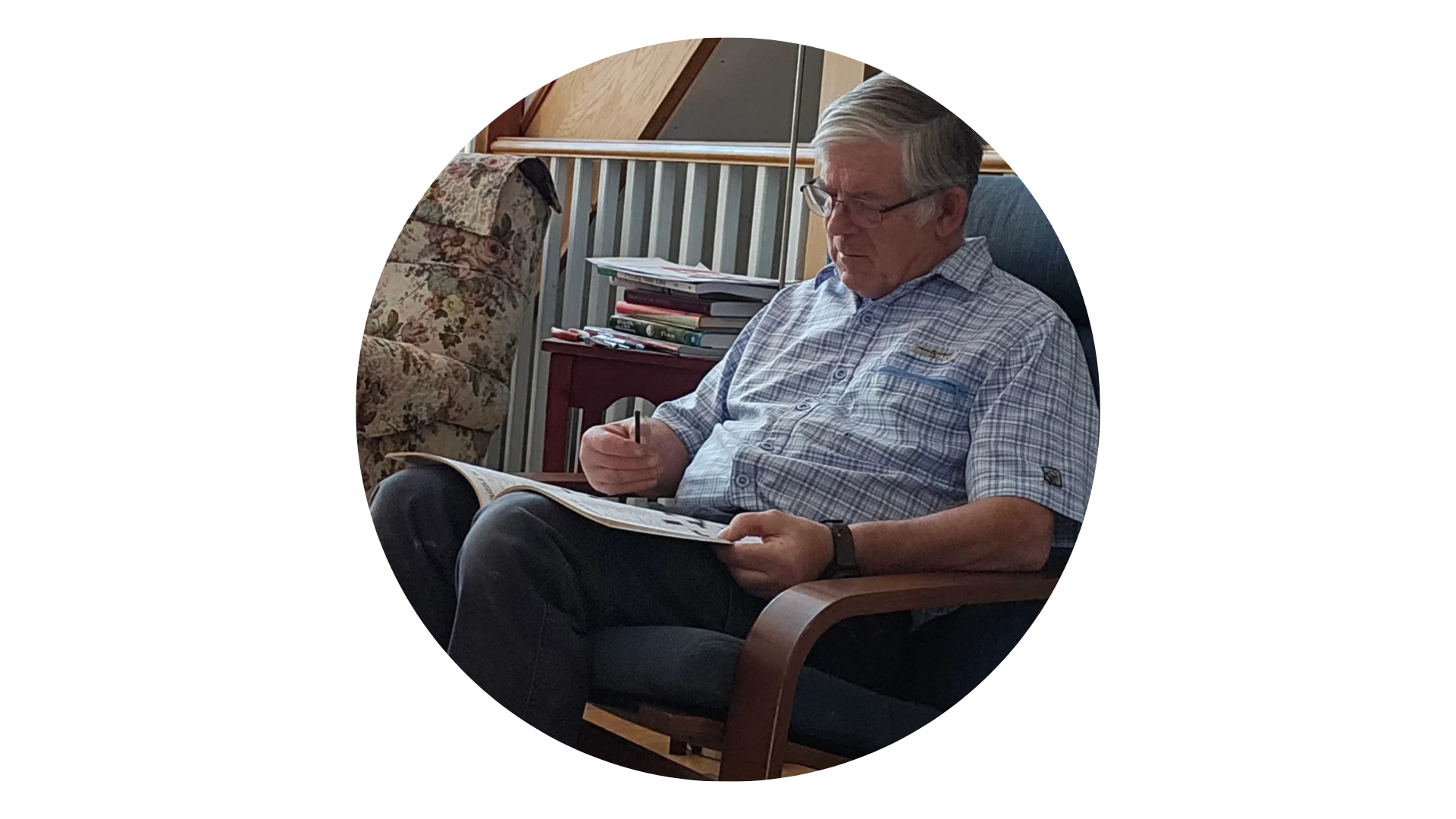 A man is sitting in a chair reading a newspaper.