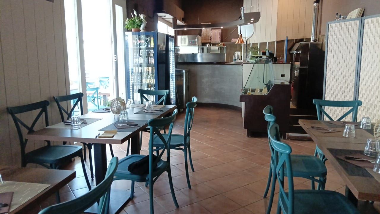 Un ristorante con molti tavoli e sedie