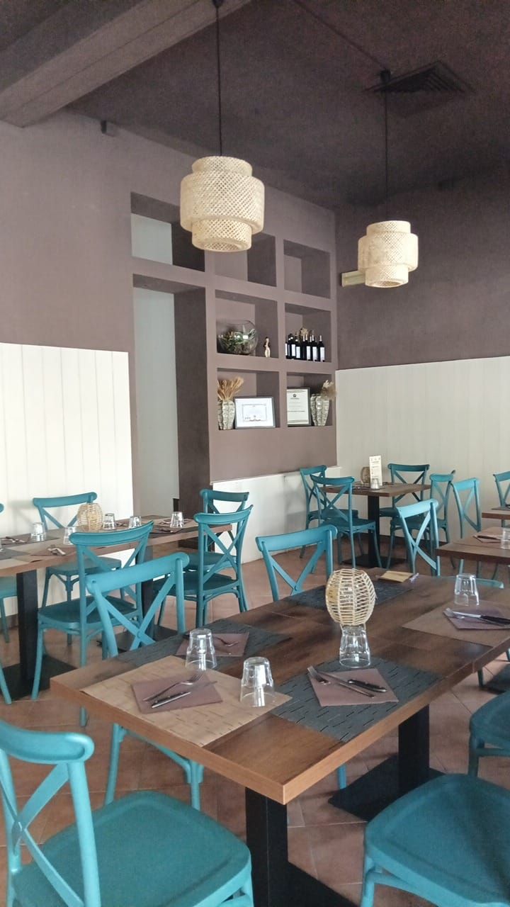 Un ristorante pieno di tavoli e sedie con bicchieri sopra