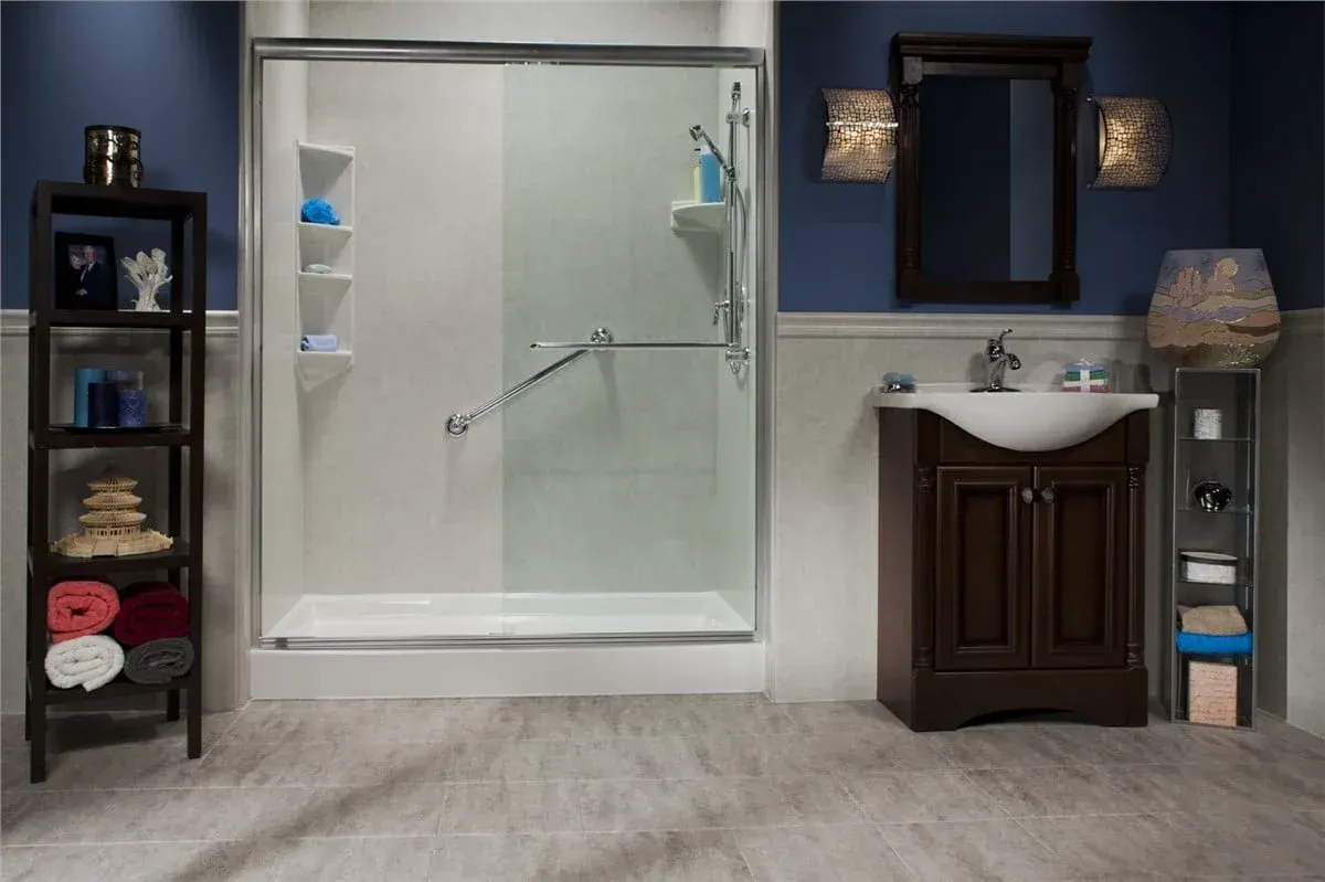 Bathroom with glass shower, sink vanity, shelves, and gray walls and flooring.