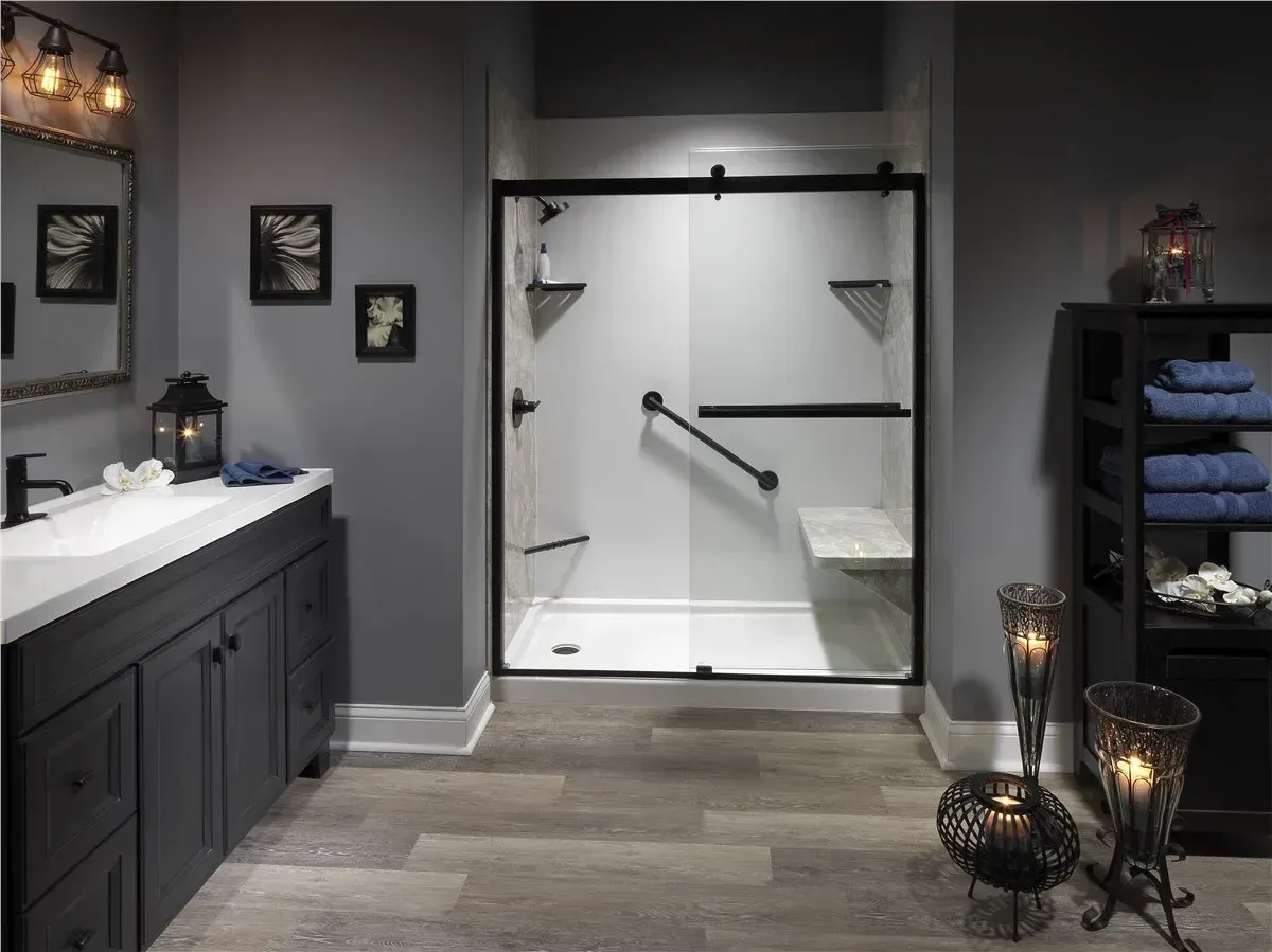 Modern bathroom with glass walk-in shower, dark vanity, and gray tile walls and floor