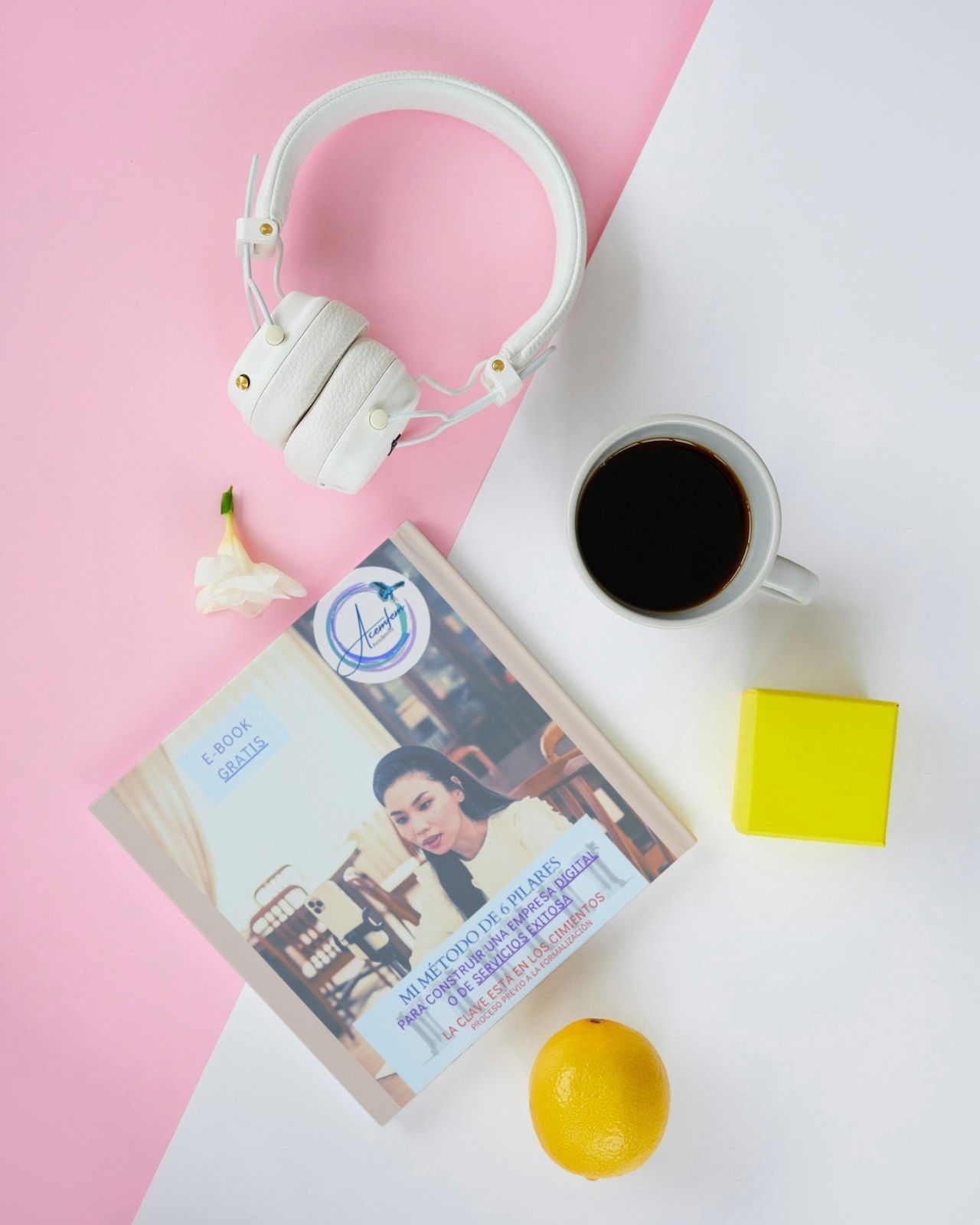 Un libro con la foto de una mujer junto a una taza de café y unos auriculares.