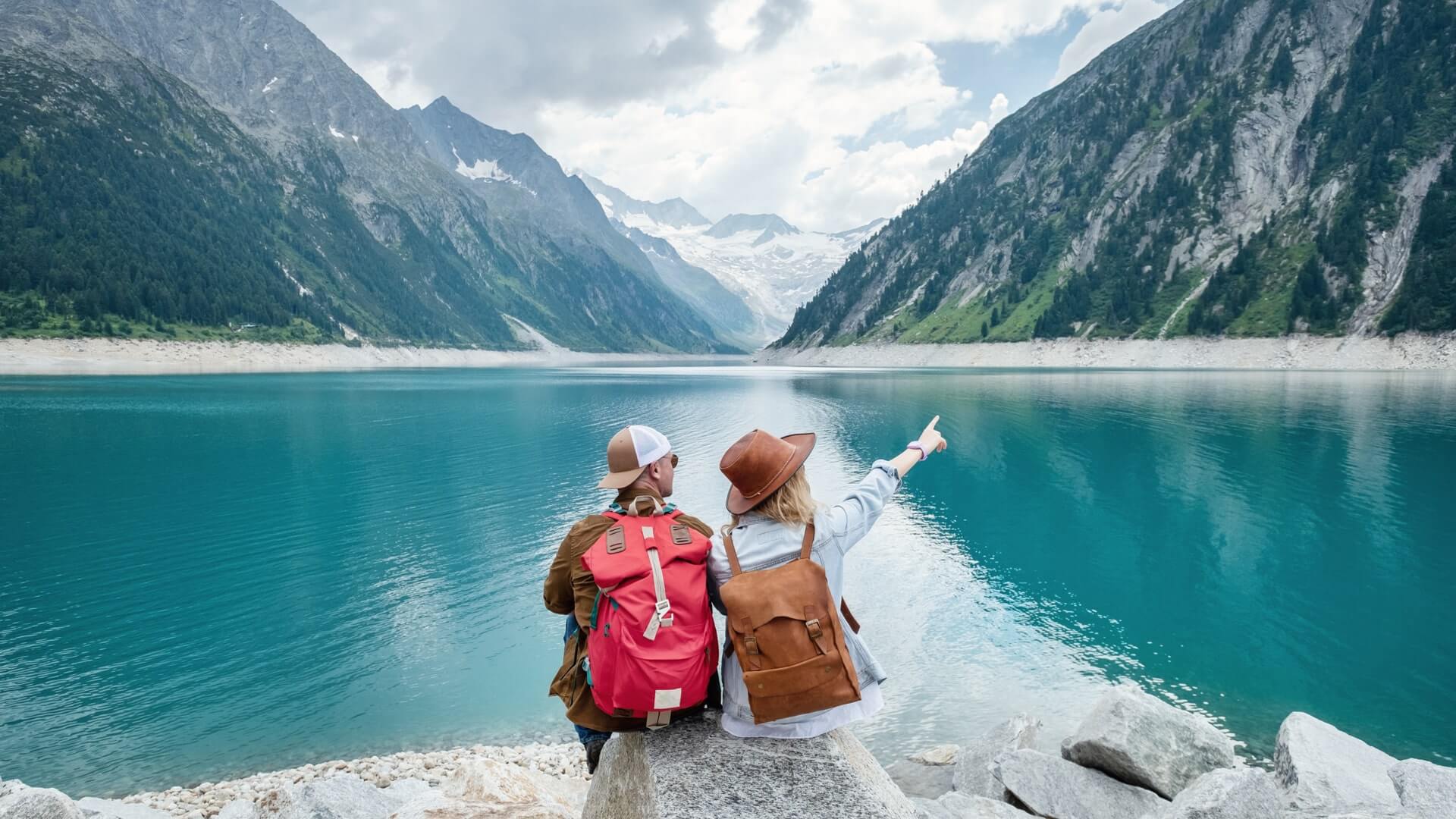 Travelers couple look at the mountain lake. Travel and active life concept with team. Adventure and travel in the mountains region in the Austria. Travel - image