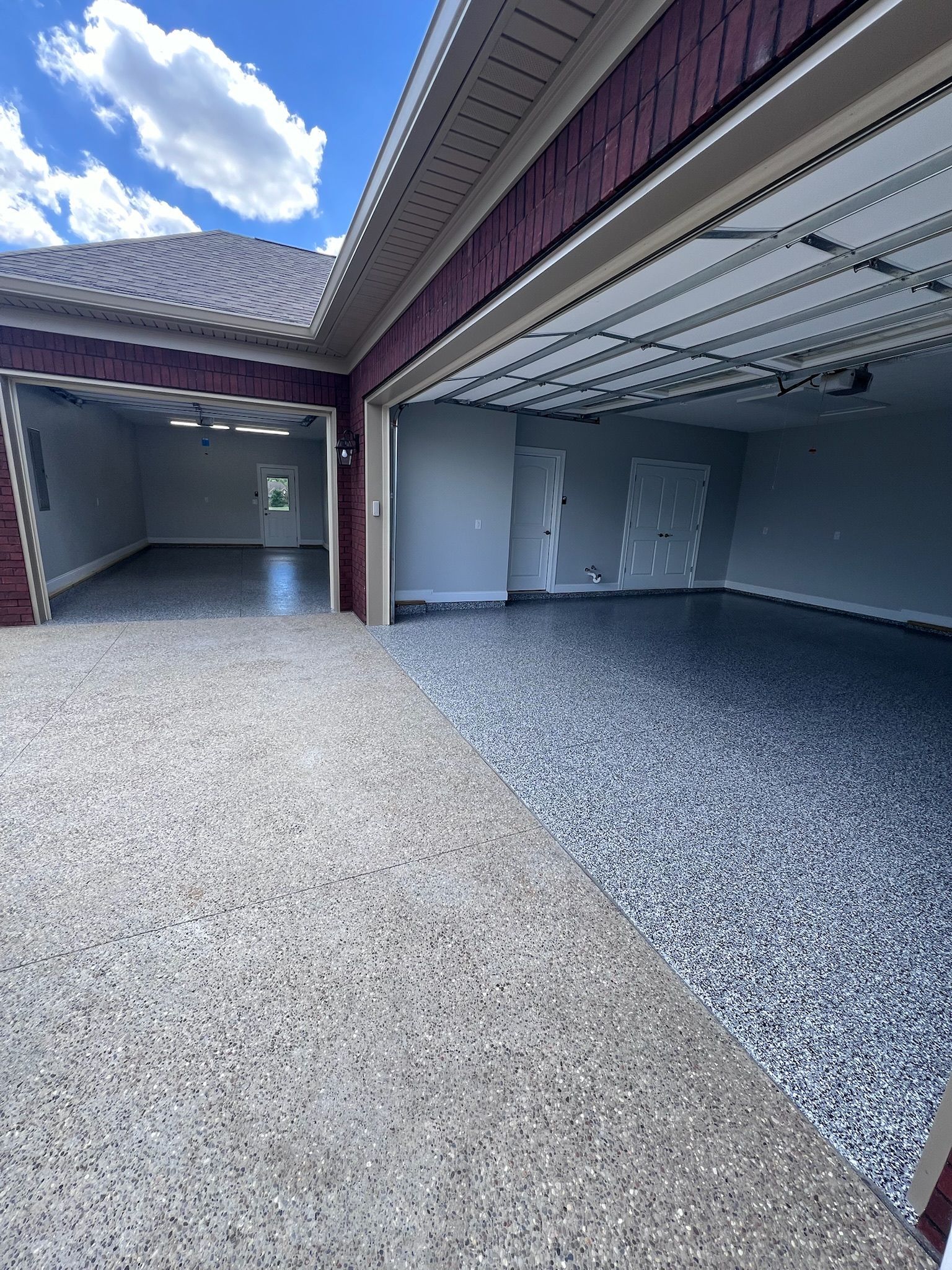 Two-car garage with epoxy-coated floors in gray and beige, open to reveal empty interior.