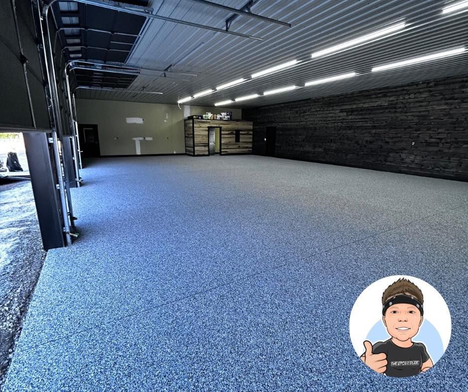Empty commercial space with epoxy floor, a dark accent wall, and inset avatar.