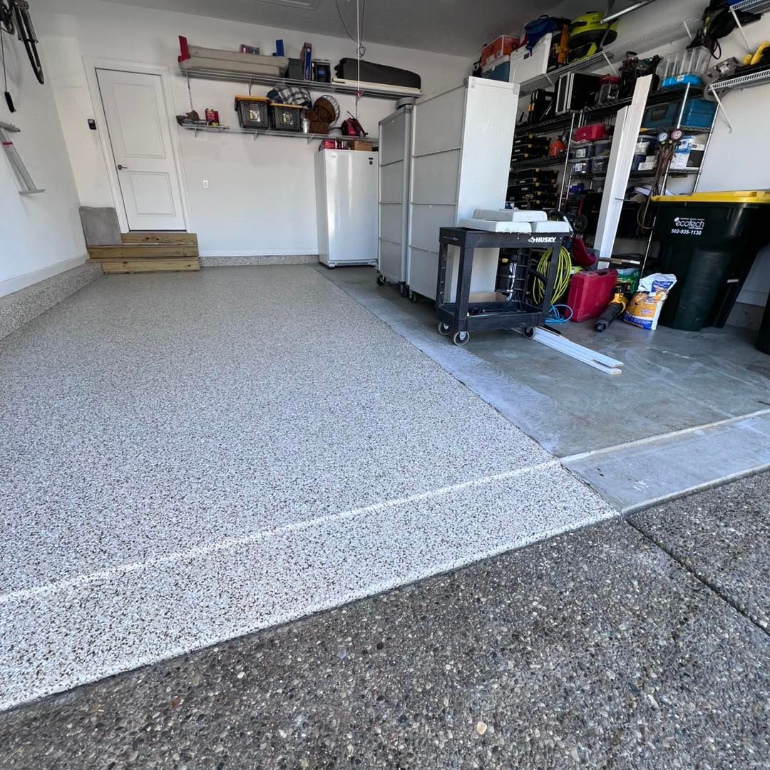 Garage interior with epoxy floor, storage cabinets, and tools.