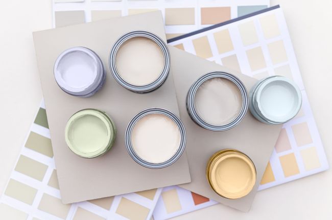 A bunch of paint cans are sitting on top of a table.