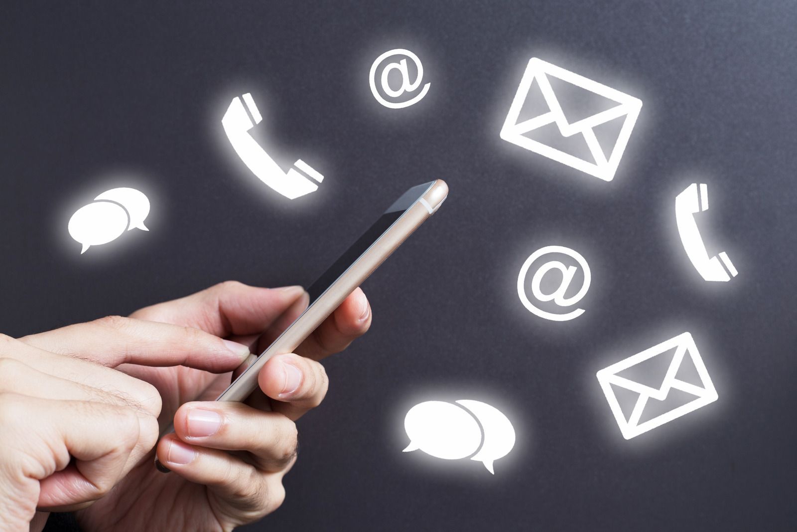 Hand holding a phone with glowing contact icons: phone, email, and chat.