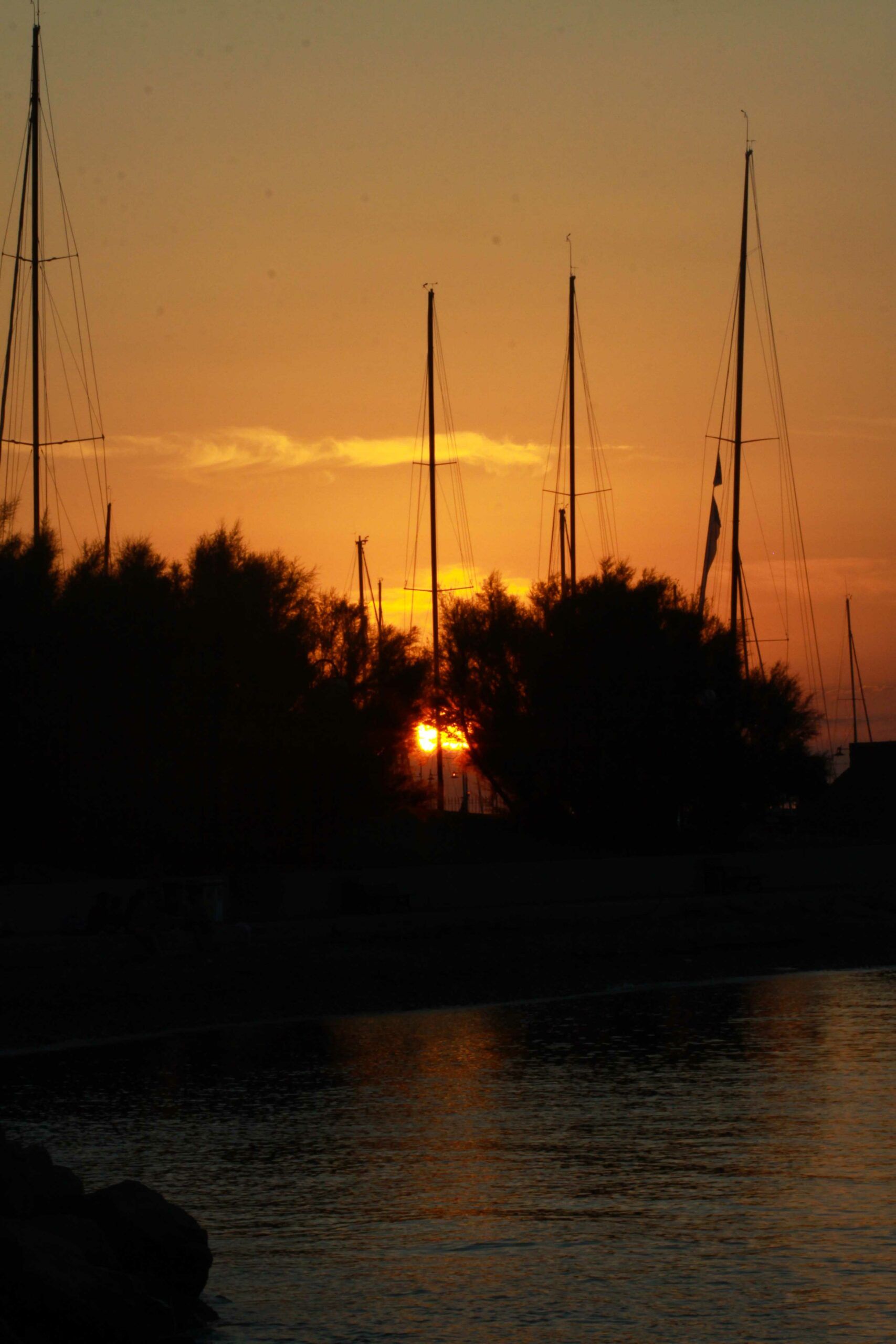 mare al tramonto con barche a vela