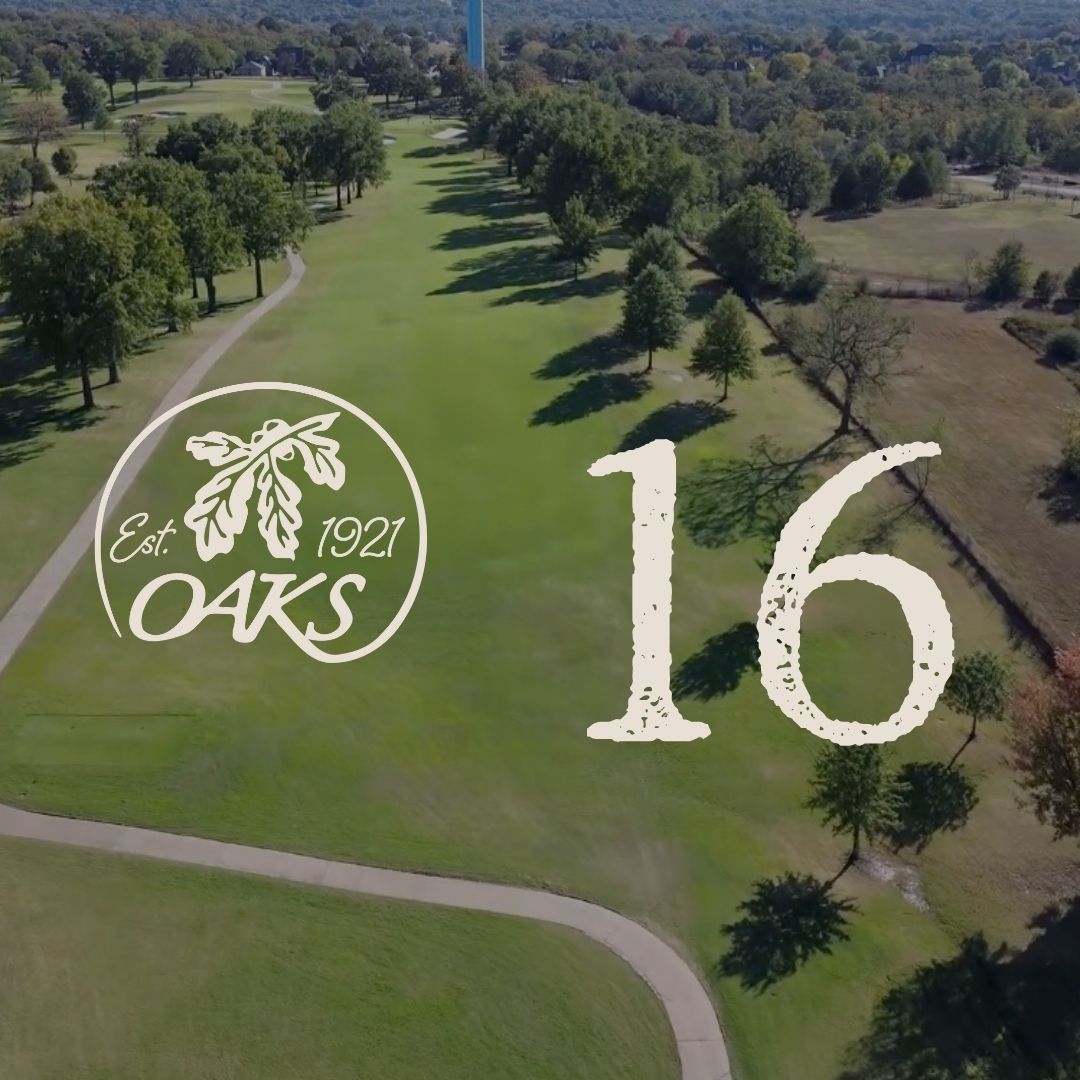 Aerial view of Oak's golf course hole 16 with logo. Green grass and trees under a blue sky, water tower in background.