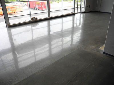 A large room with a shiny concrete floor and a lot of windows.