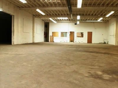 An empty warehouse with a concrete floor and white walls