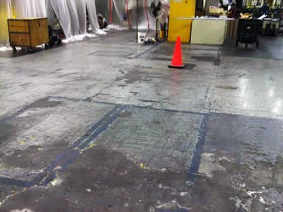 An orange cone is sitting on the floor of a warehouse.