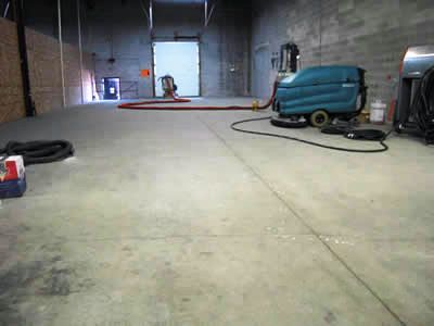 A warehouse with a vacuum cleaner on the floor.