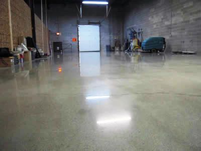 A warehouse with a shiny concrete floor and a vacuum cleaner.