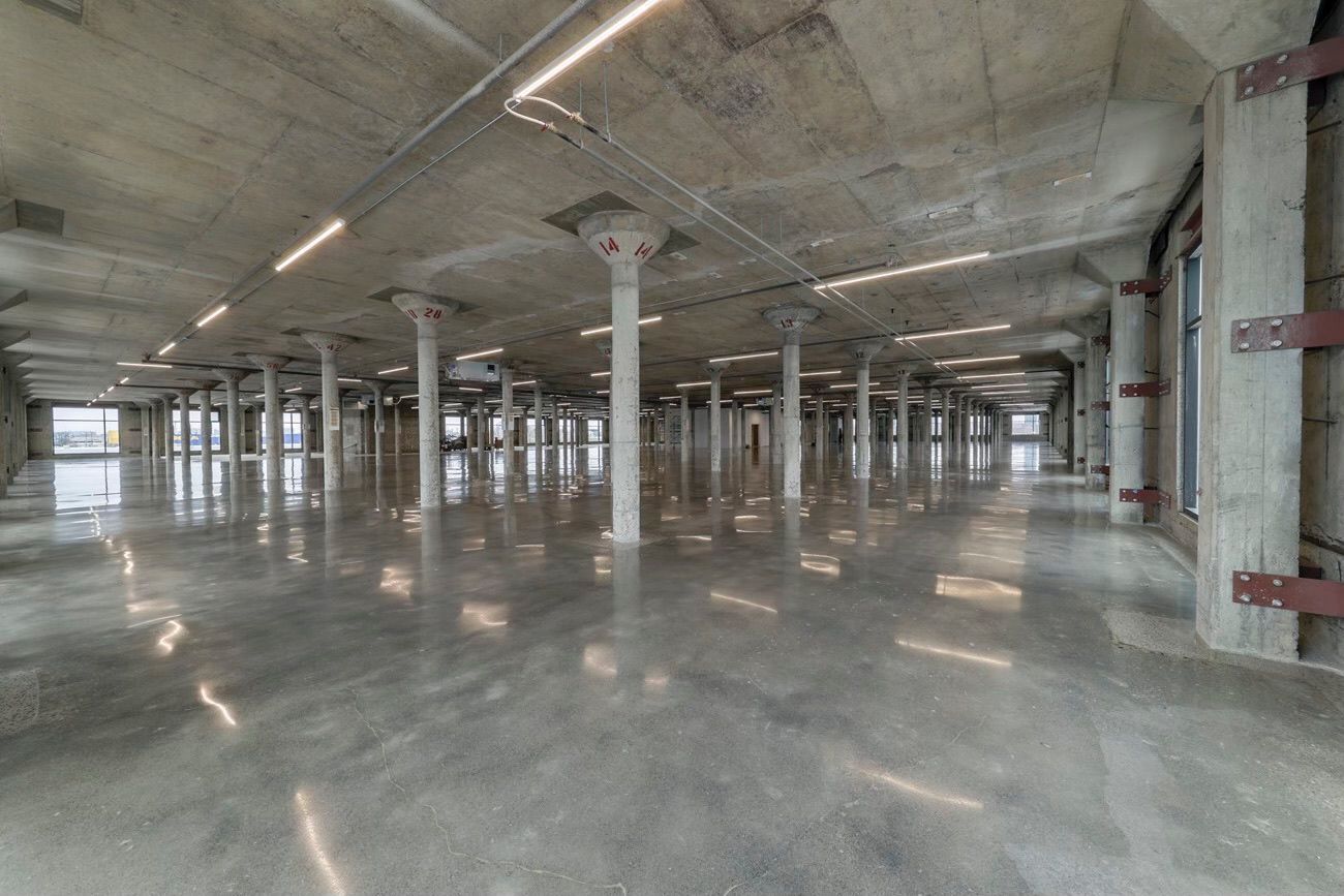 A large empty warehouse with concrete floors and columns.