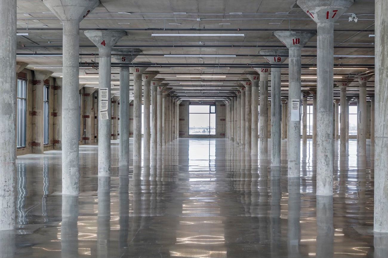 A large empty room with concrete pillars and columns