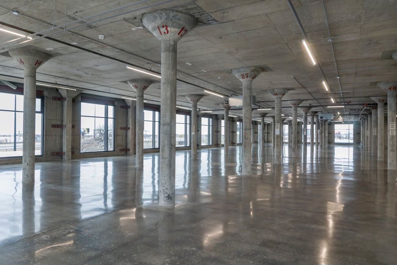 A large empty room with a lot of windows and columns.