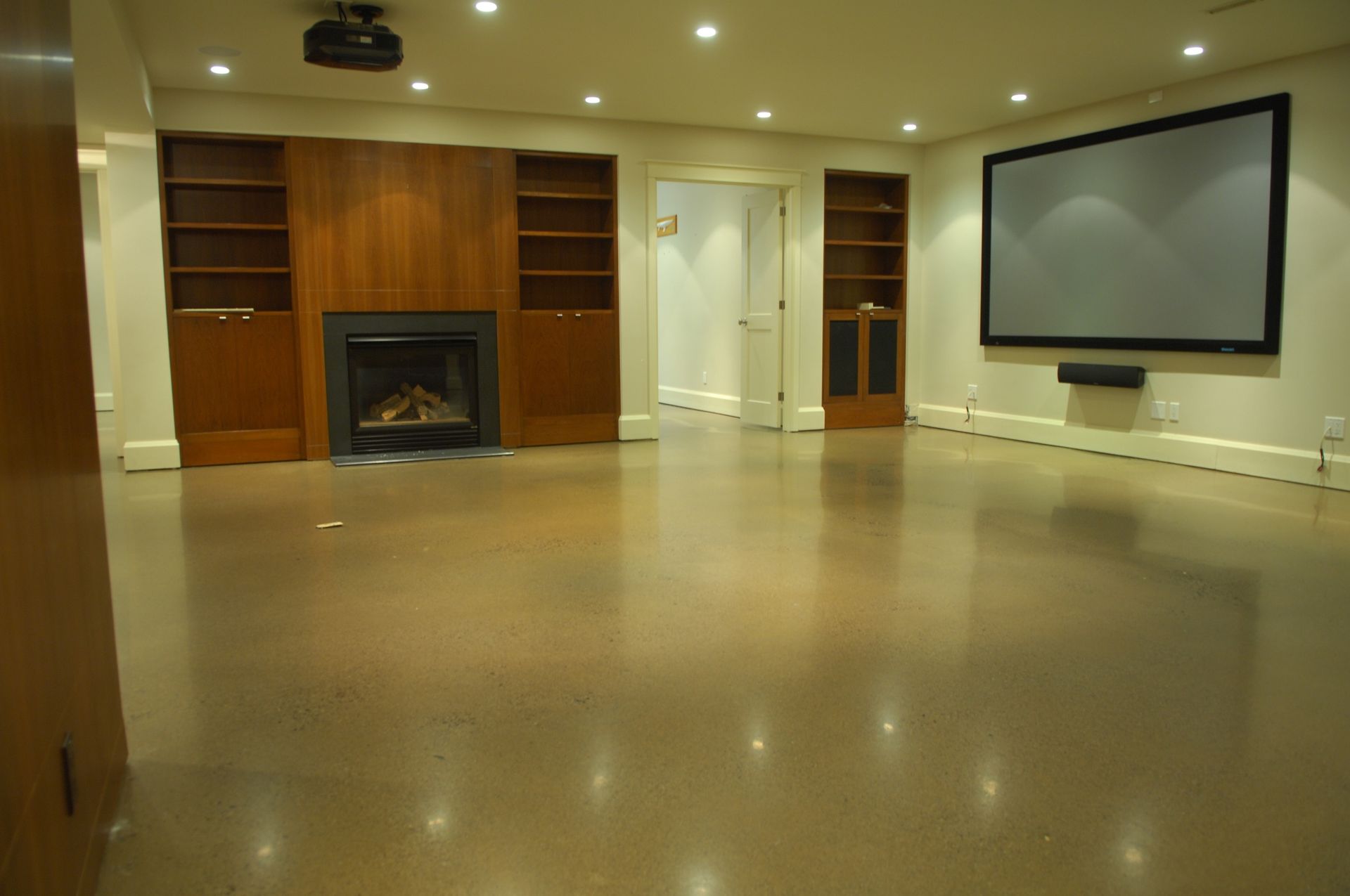 An empty basement with a fireplace and a flat screen tv
