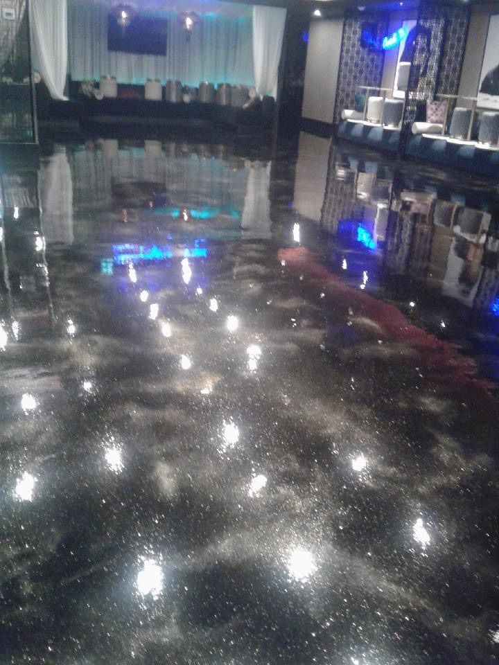 A shiny black floor in a room with a lot of lights on it.