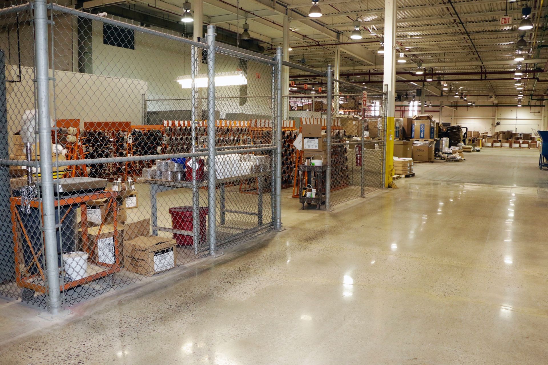 A large warehouse with a chain link fence surrounding it