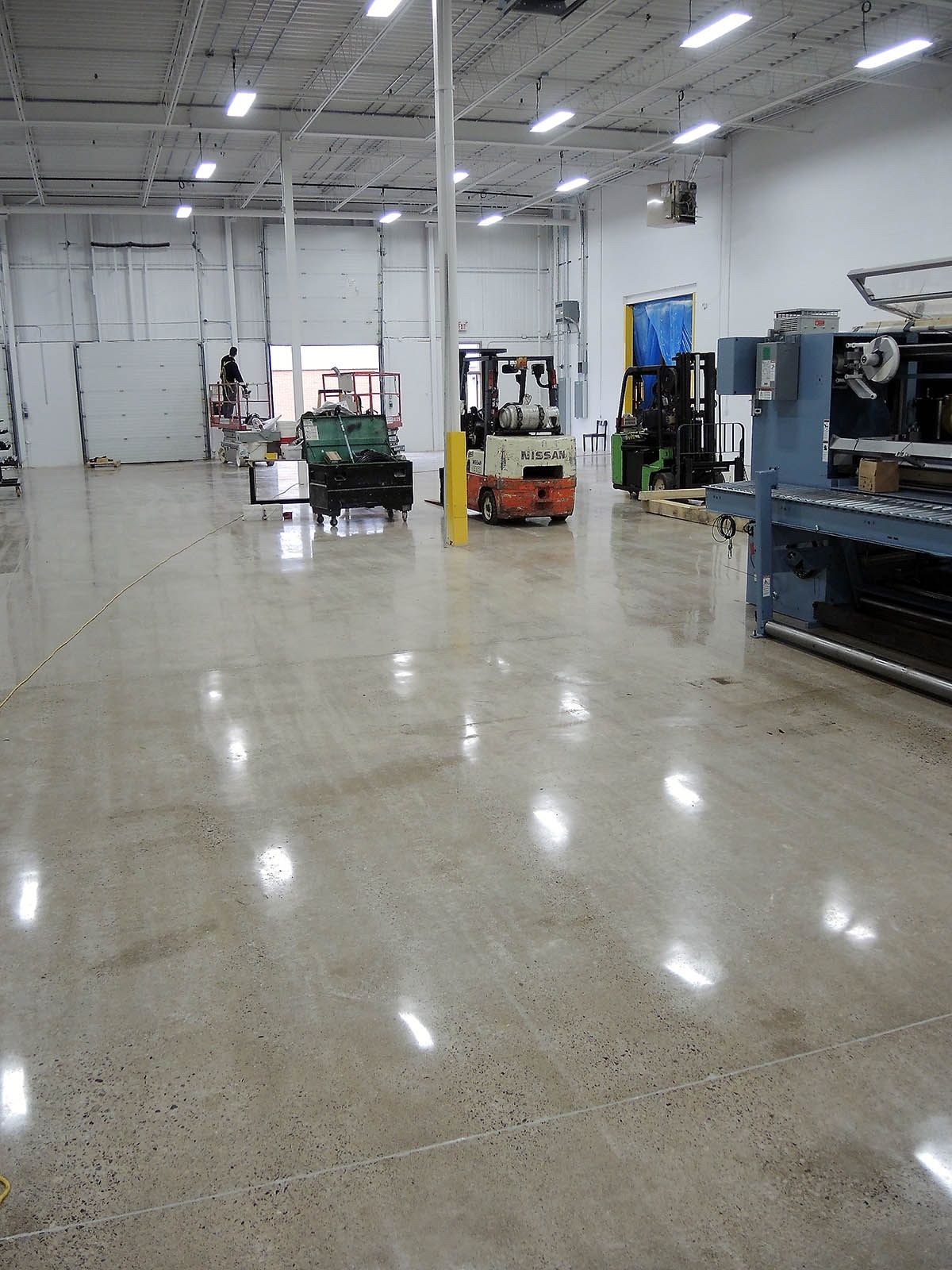 A large warehouse with a lot of machinery on the floor.