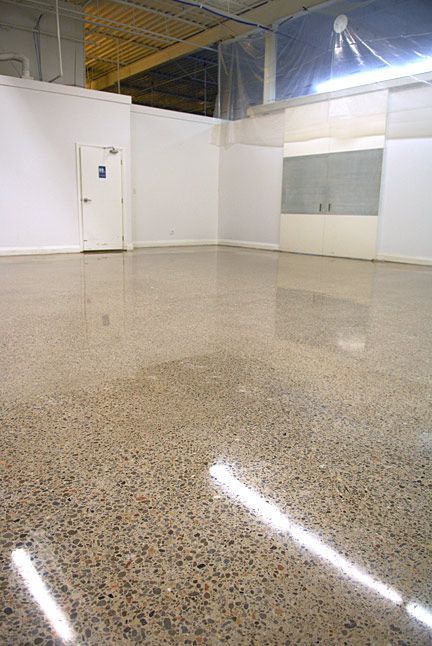 A large empty room with a shiny concrete floor and white walls.