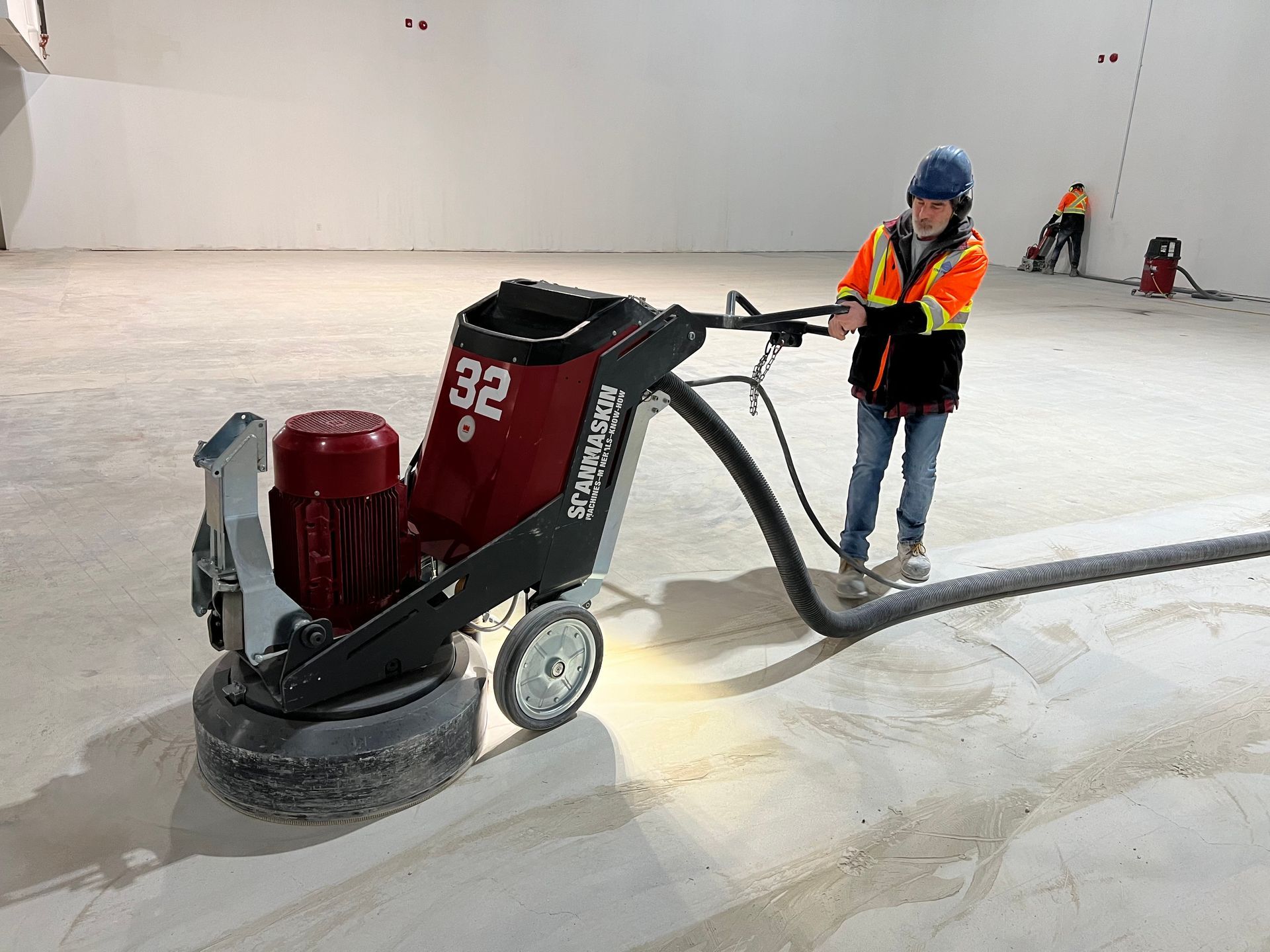 A man is using a machine to polish a concrete floor.
