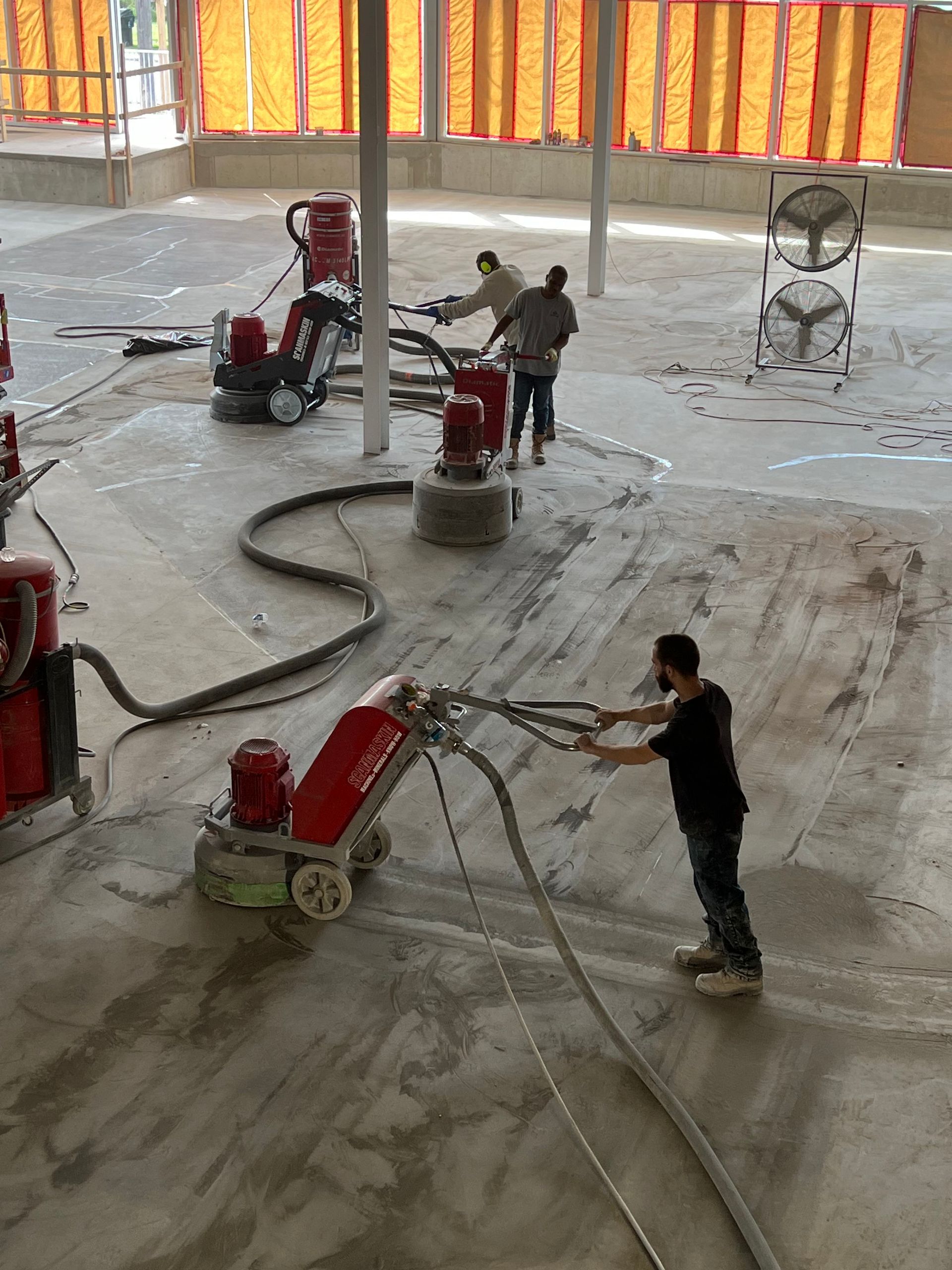 A man is using a machine to polish a concrete floor.