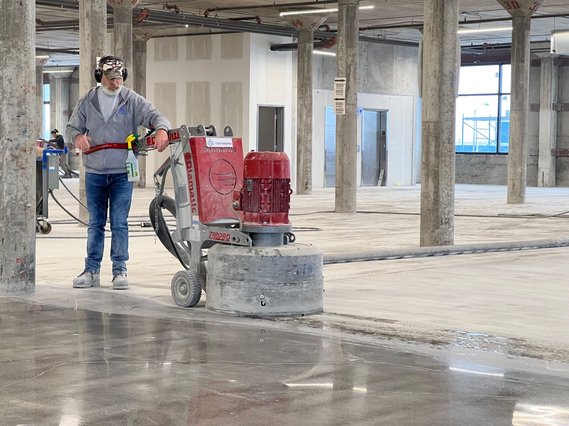 A man is using a machine to polish a concrete floor.
