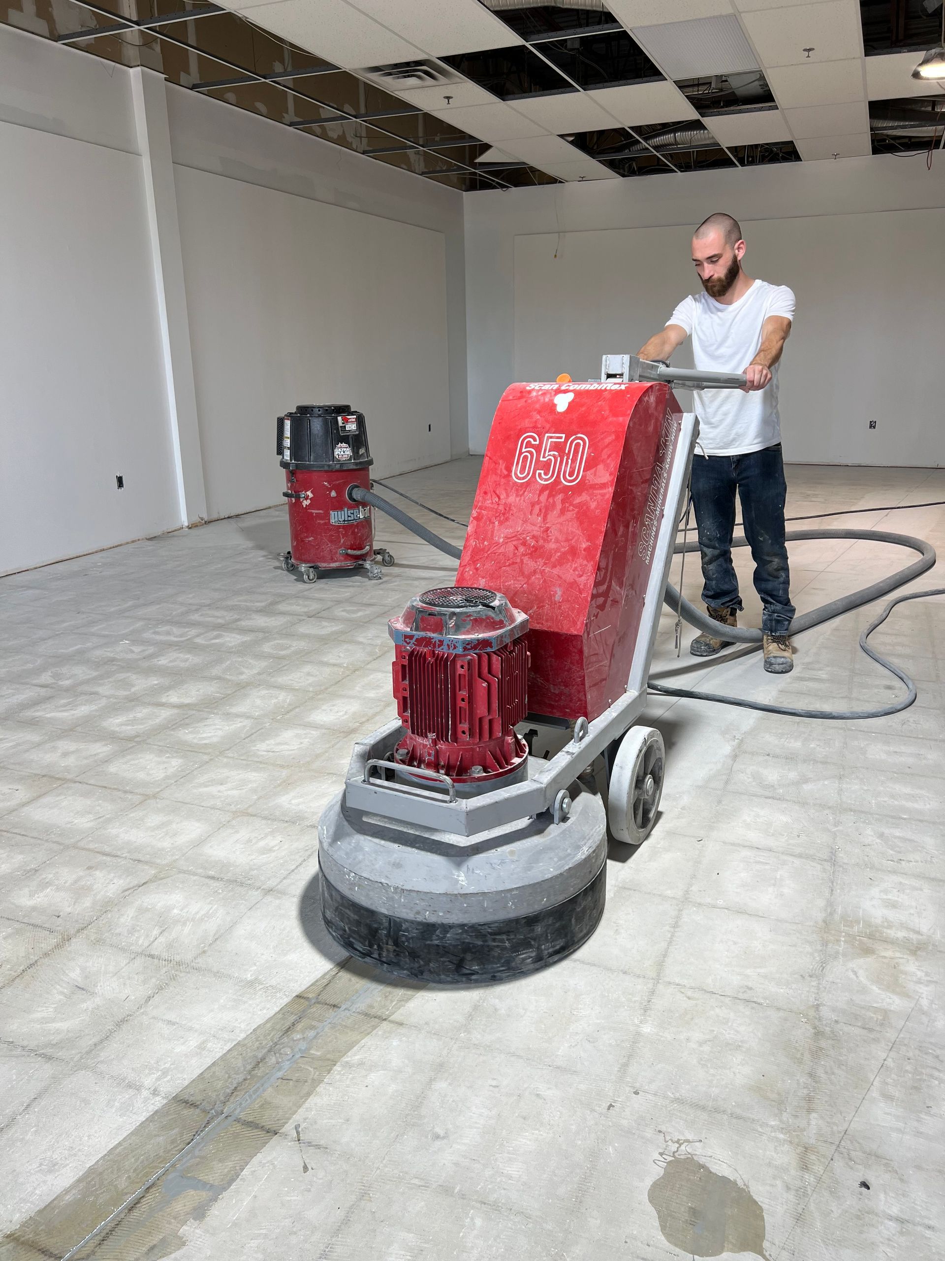 A man is using a machine to polish a tile floor.
