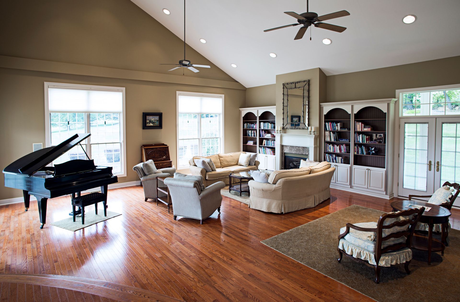 A living room with a piano and a ceiling fan