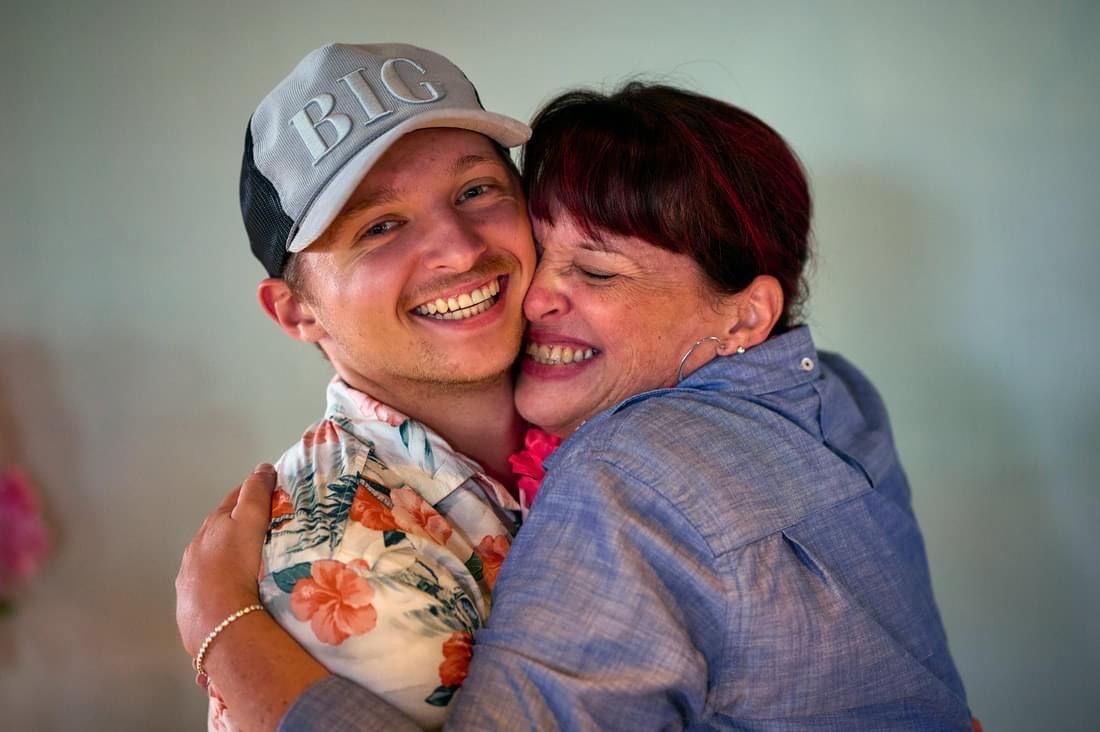 A man wearing a big hat is hugging a woman.