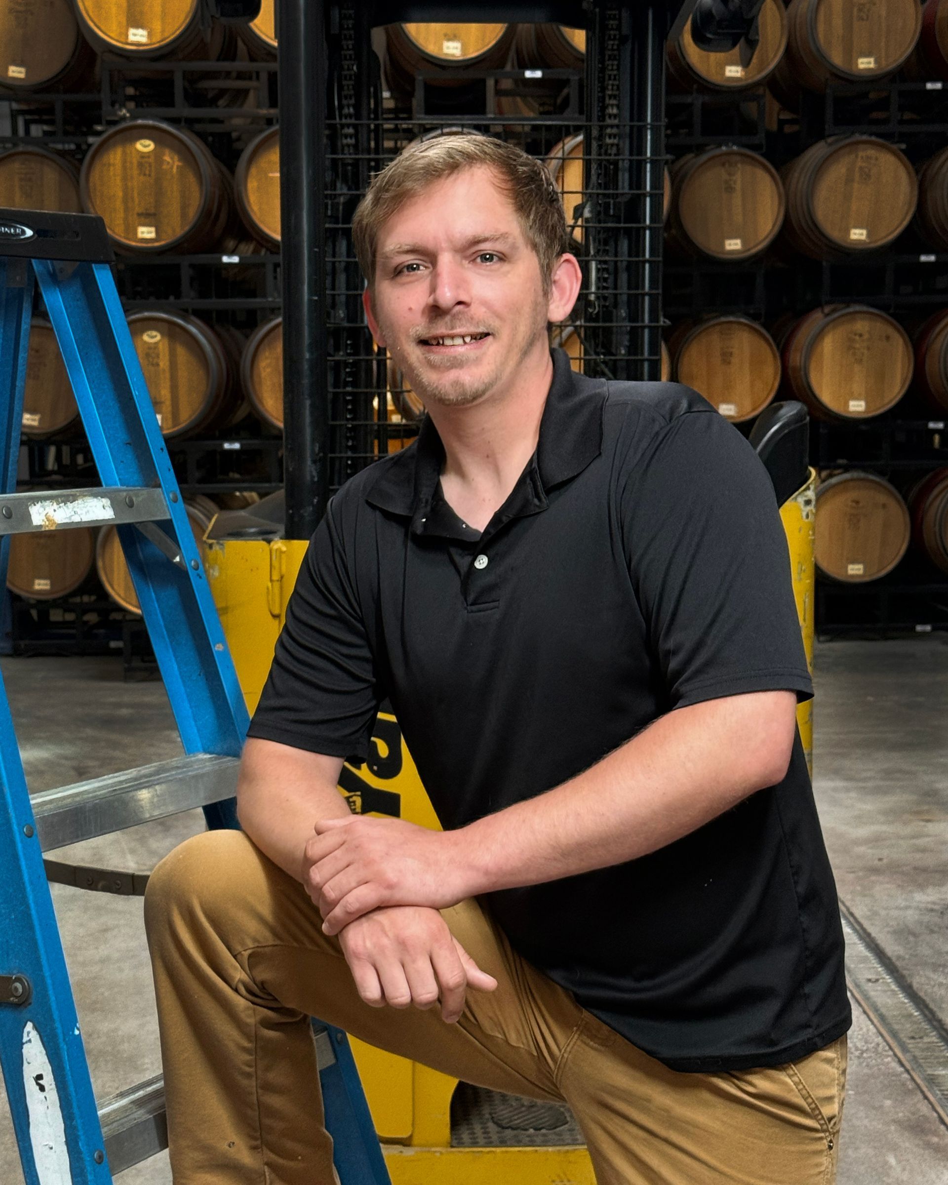 A man in a green shirt is holding a glass of wine