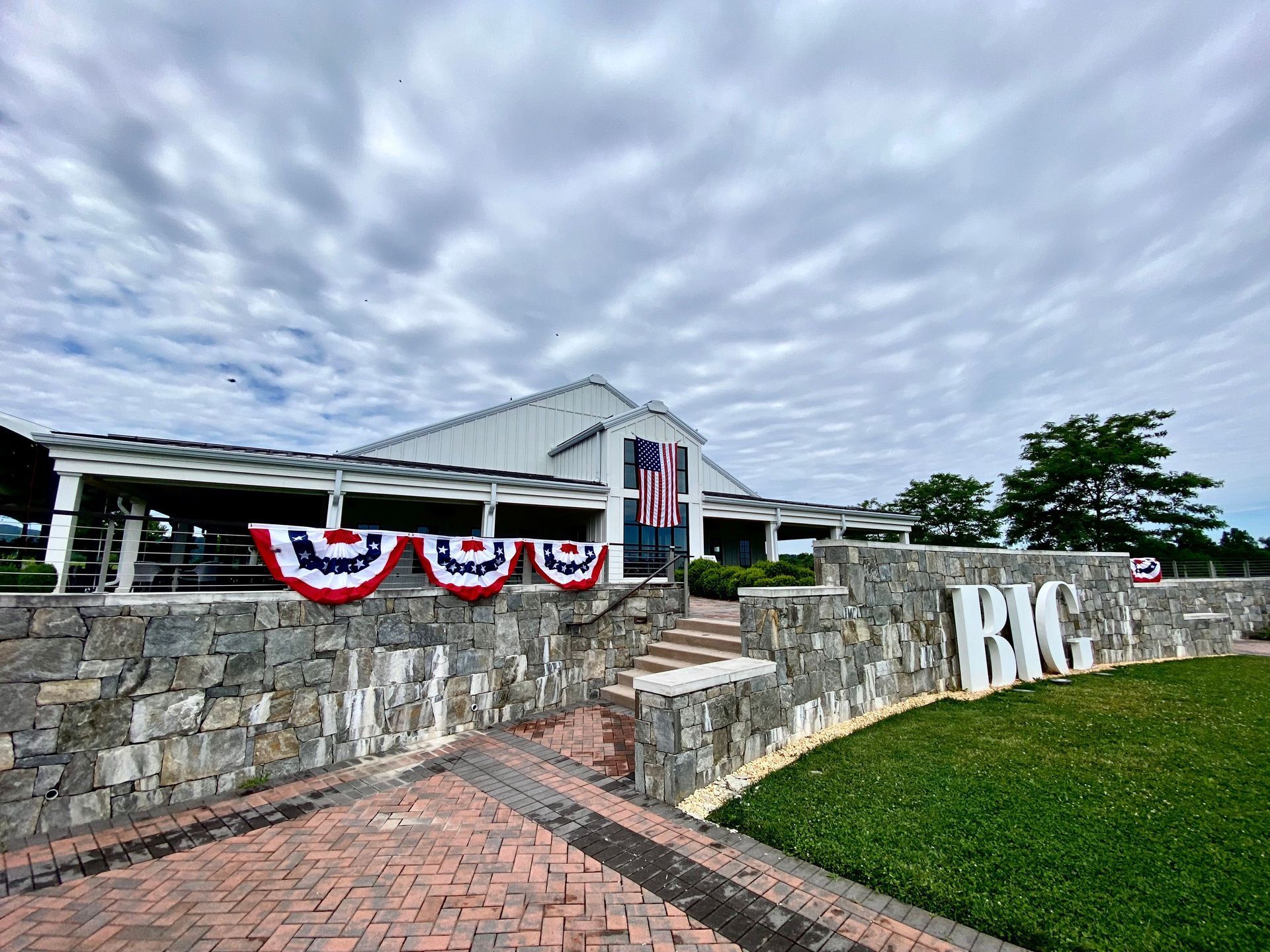 A large white building with red , white and blue flags on the side of it.