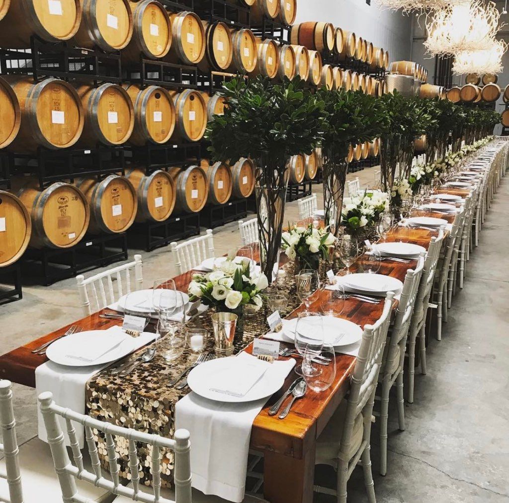 A long table is set for a wedding reception in a wine cellar.