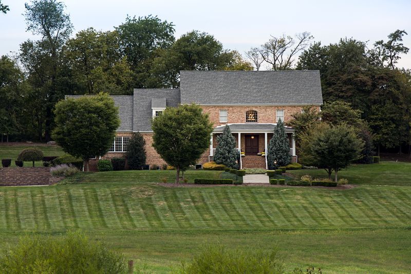 A large brick house with a large lawn in front of it