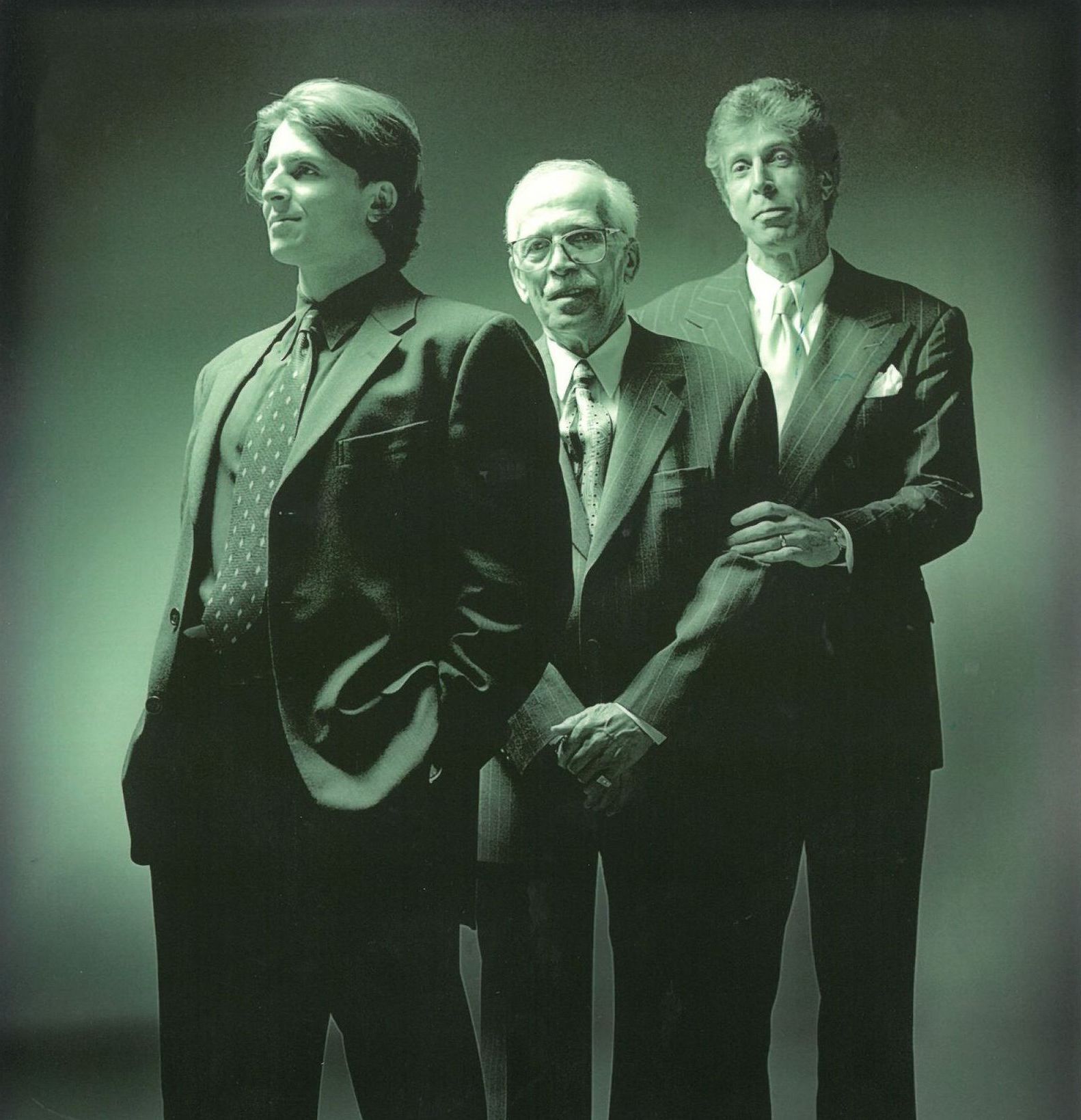 Three men in suits and ties are standing next to each other