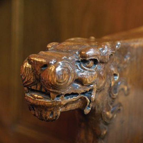 A close up of a wooden carving of a dragon 's head.