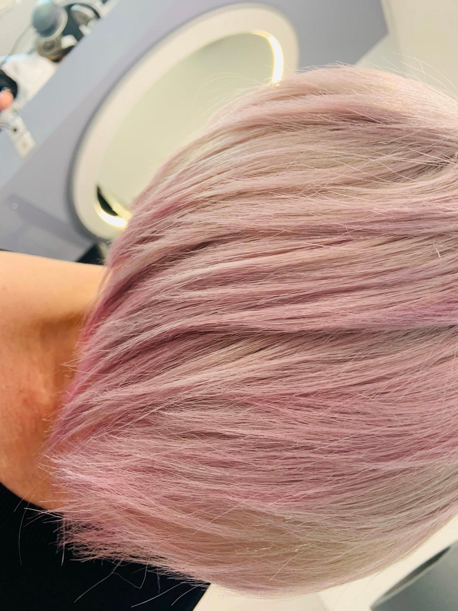Primo piano di capelli viola chiaro acconciati, probabilmente in un salone di bellezza.