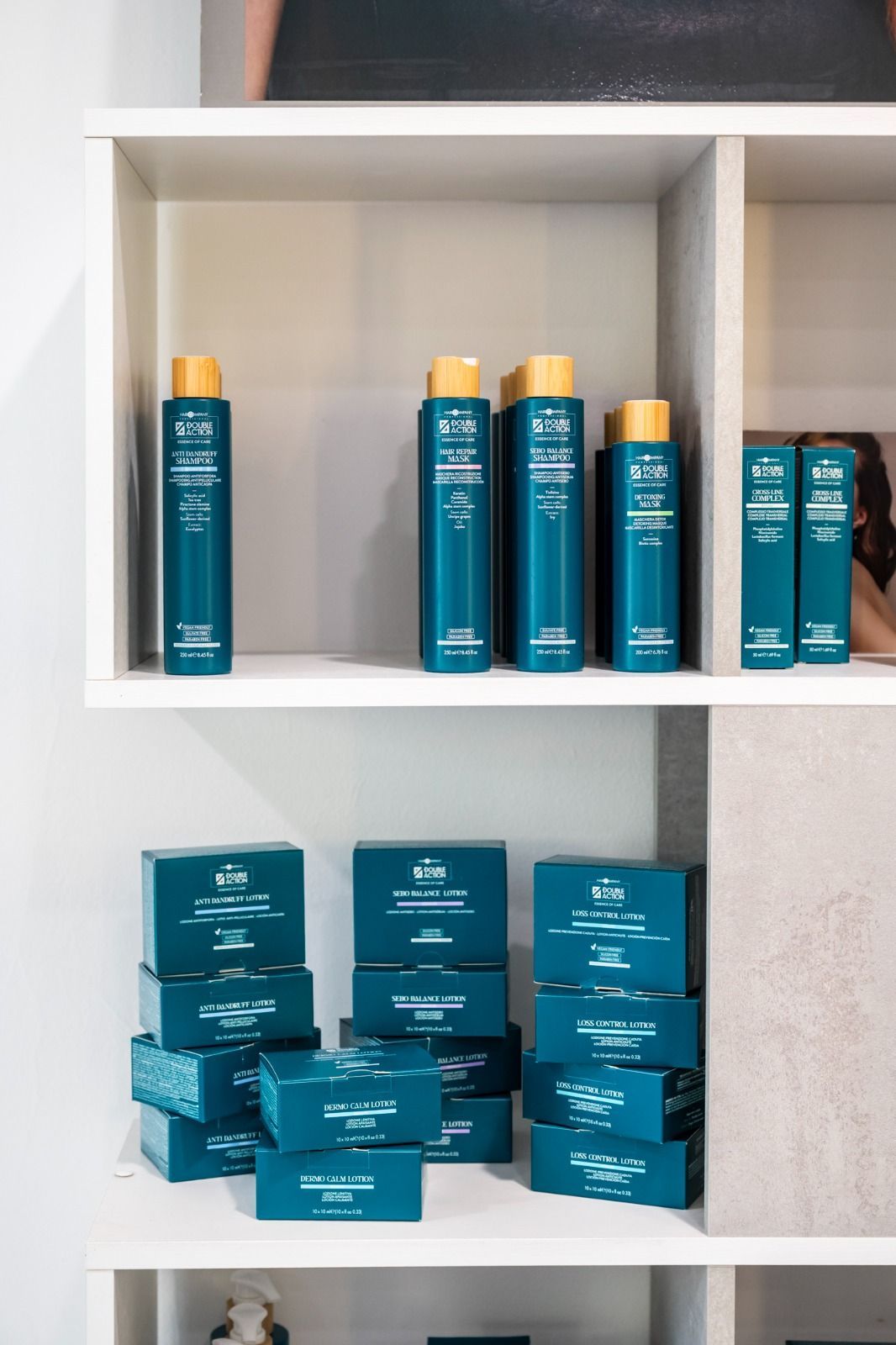 Mensola bianca con prodotti per la cura dei capelli color verde acqua.