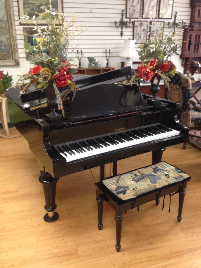 A black grand piano with a bench in front of it