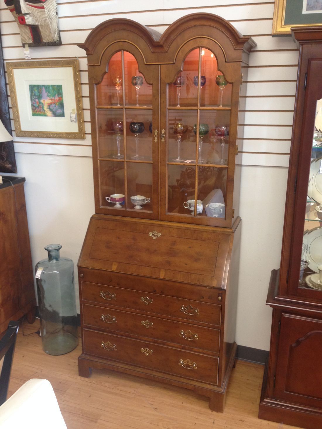 A wooden cabinet with glass doors and drawers in a room