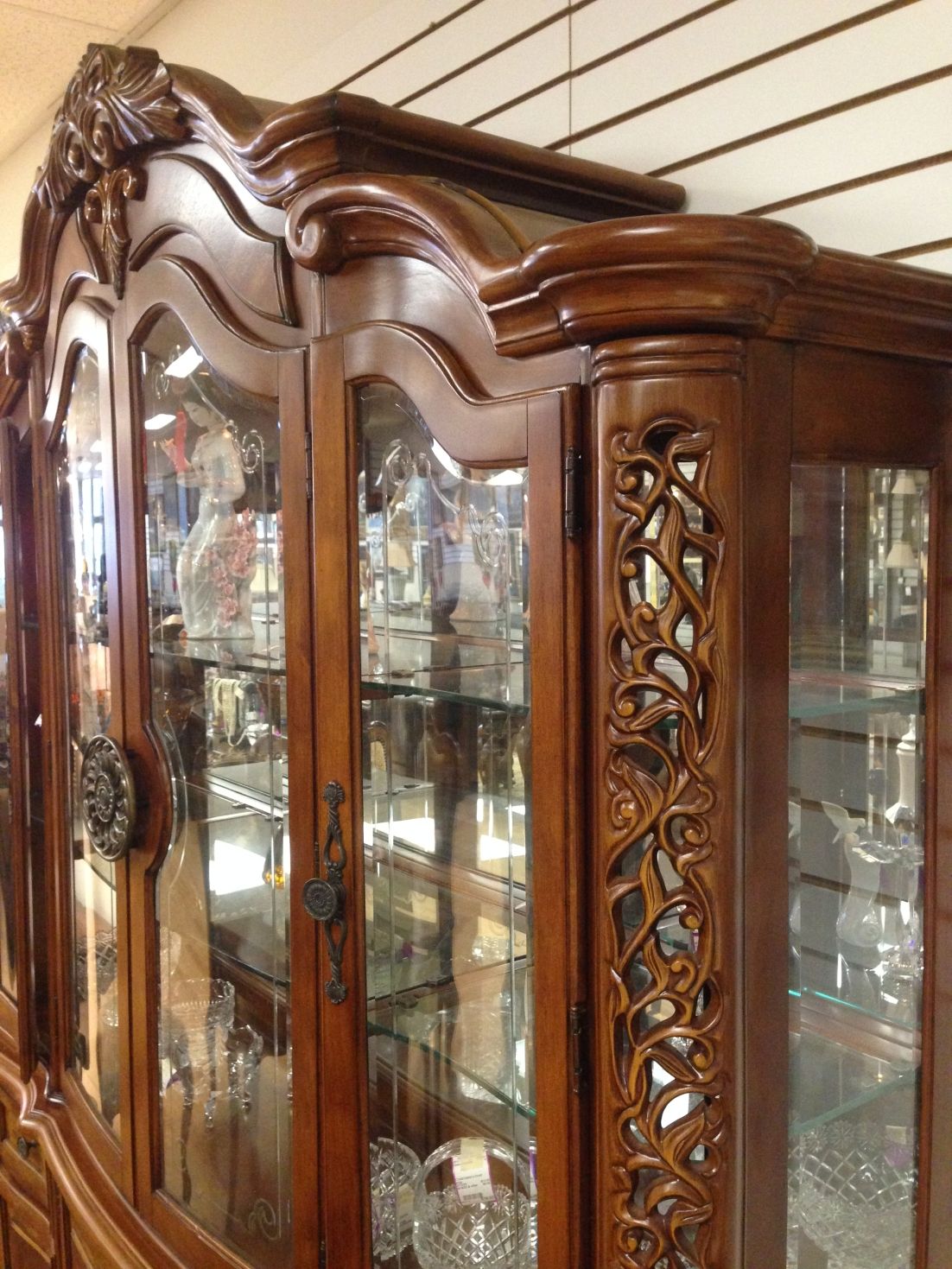 A large wooden display case with glass doors and shelves