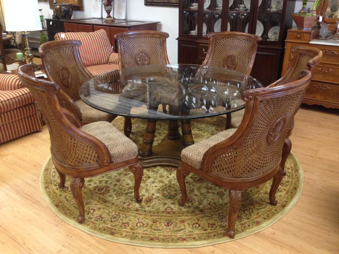 A dining room set with a glass table and chairs
