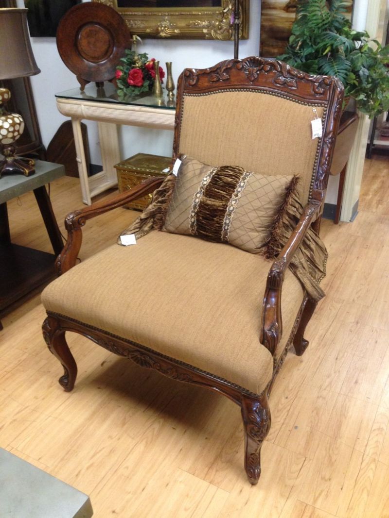 A chair with a pillow on it is sitting on a wooden floor