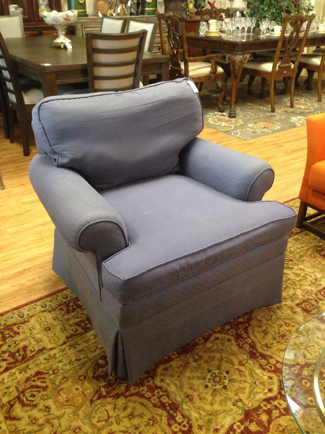 A blue chair is sitting on a rug in a living room.