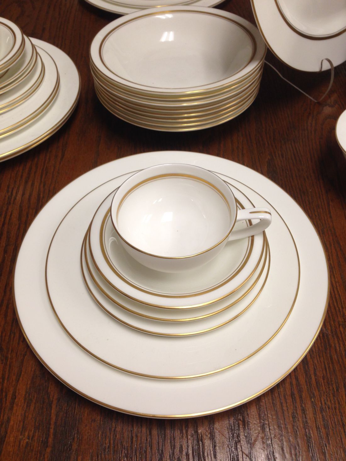 A stack of white plates and bowls on a wooden table