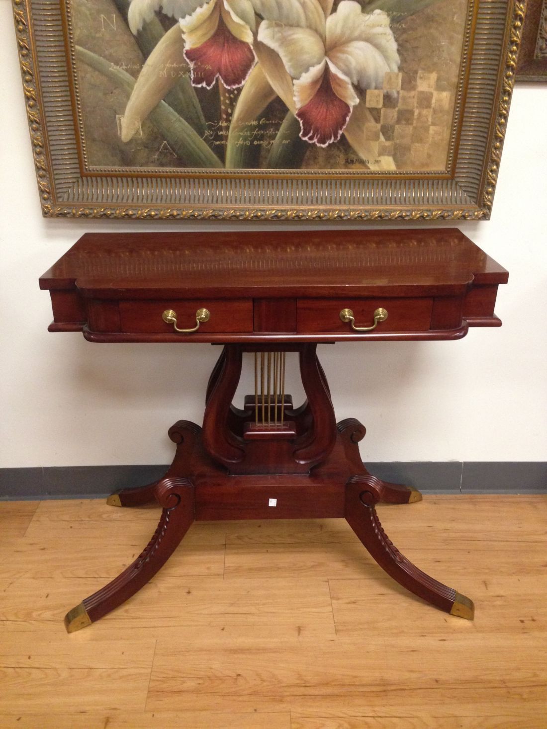 A wooden table under a painting of flowers