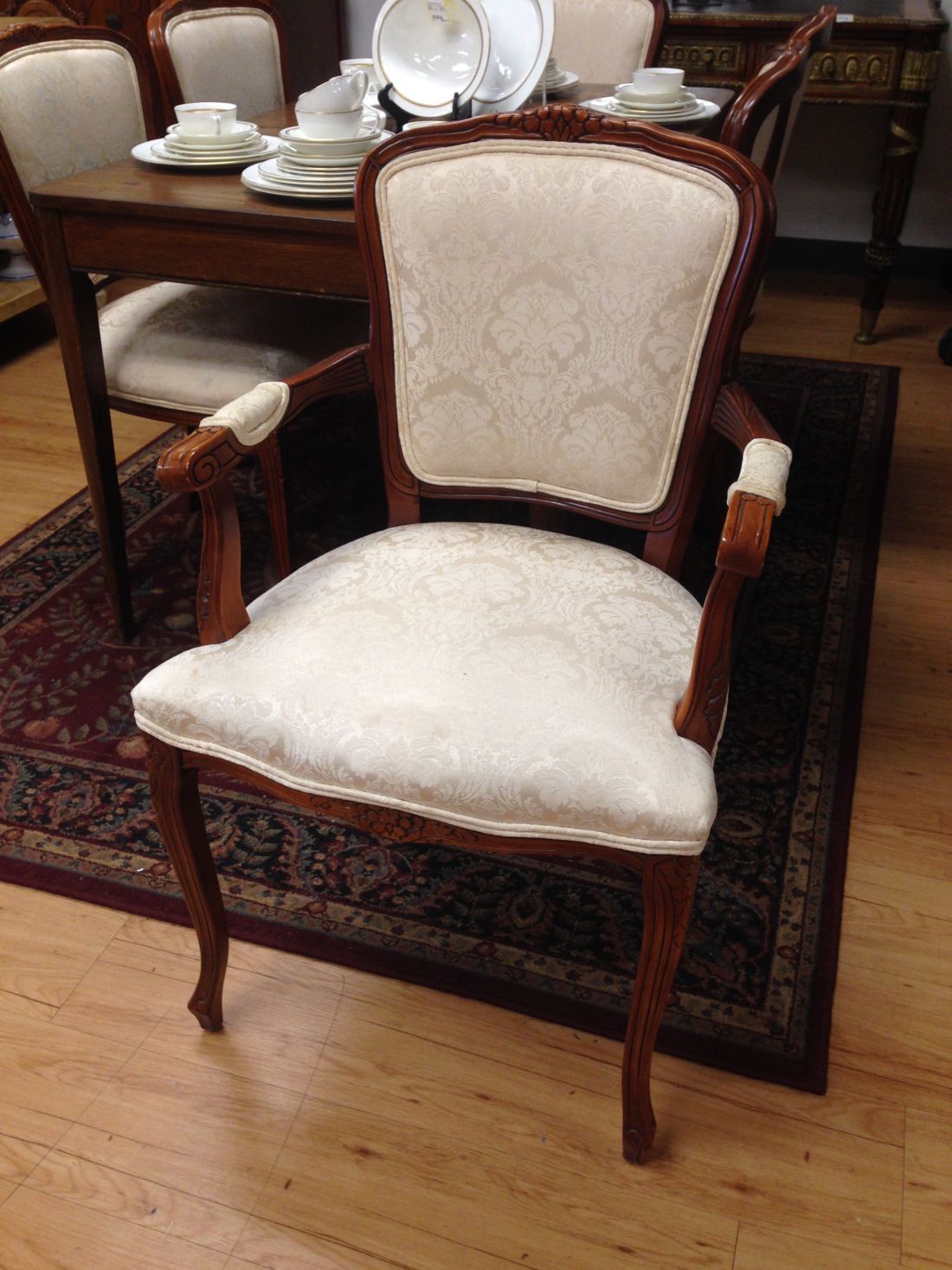 A chair is sitting on a rug in front of a table with plates on it.